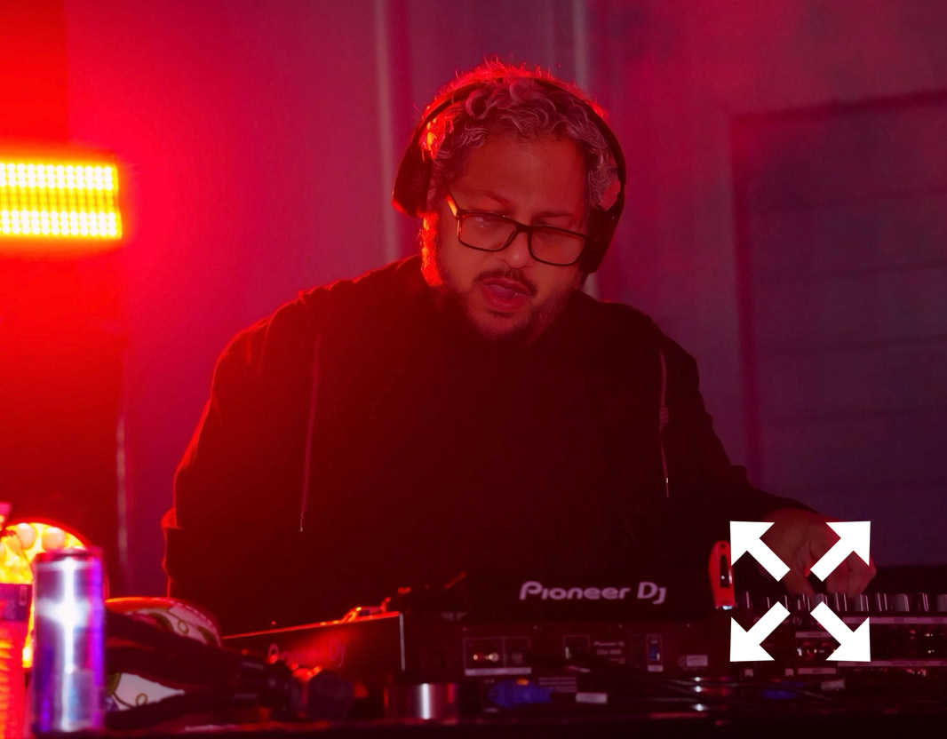 DJ playing music at a nightclub, engaging audience with dynamic beats and lively atmosphere.