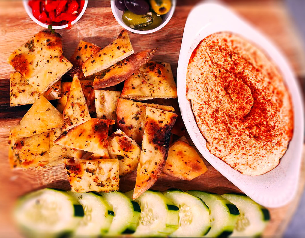 A professional chef in Dubai presents a platter of vibrant sushi rolls at a luxurious restaurant setting.