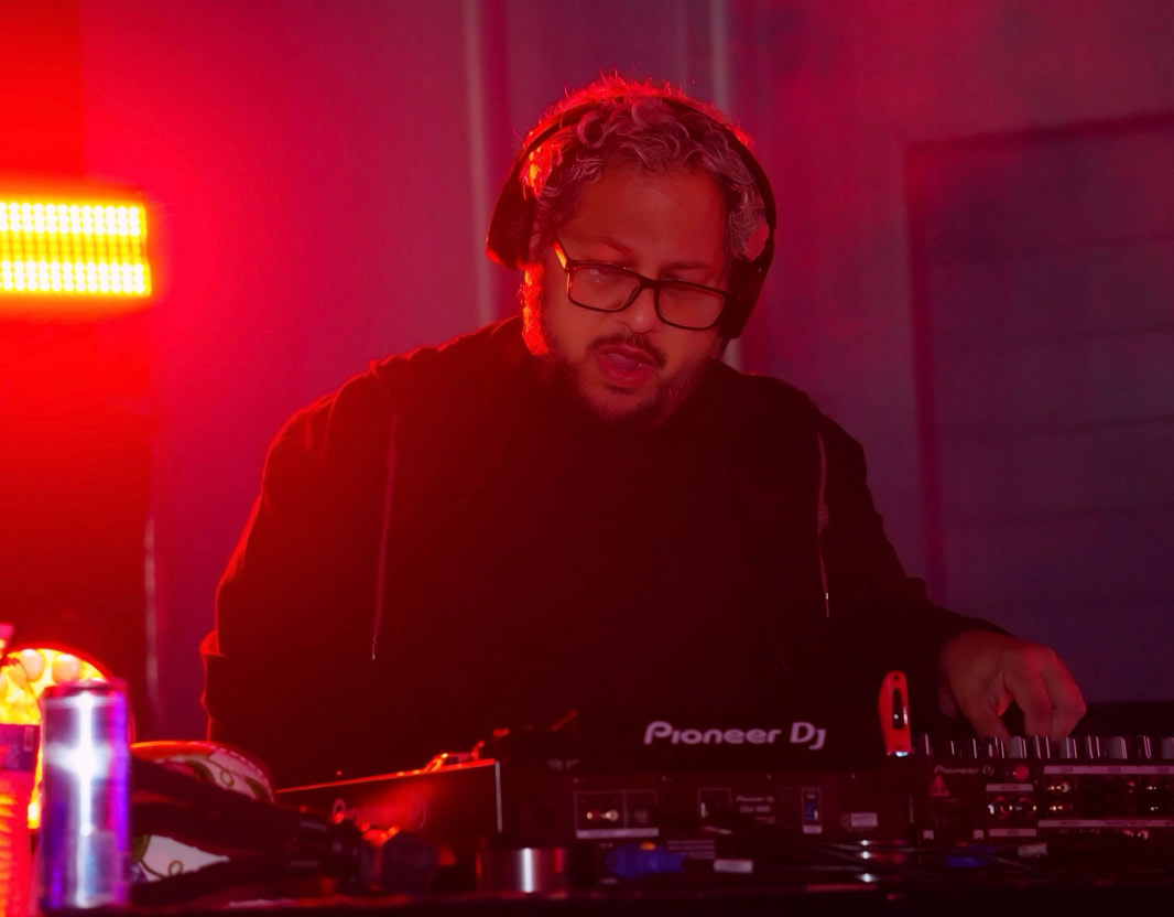 DJ playing music at a nightclub, engaging audience with dynamic beats and lively atmosphere.