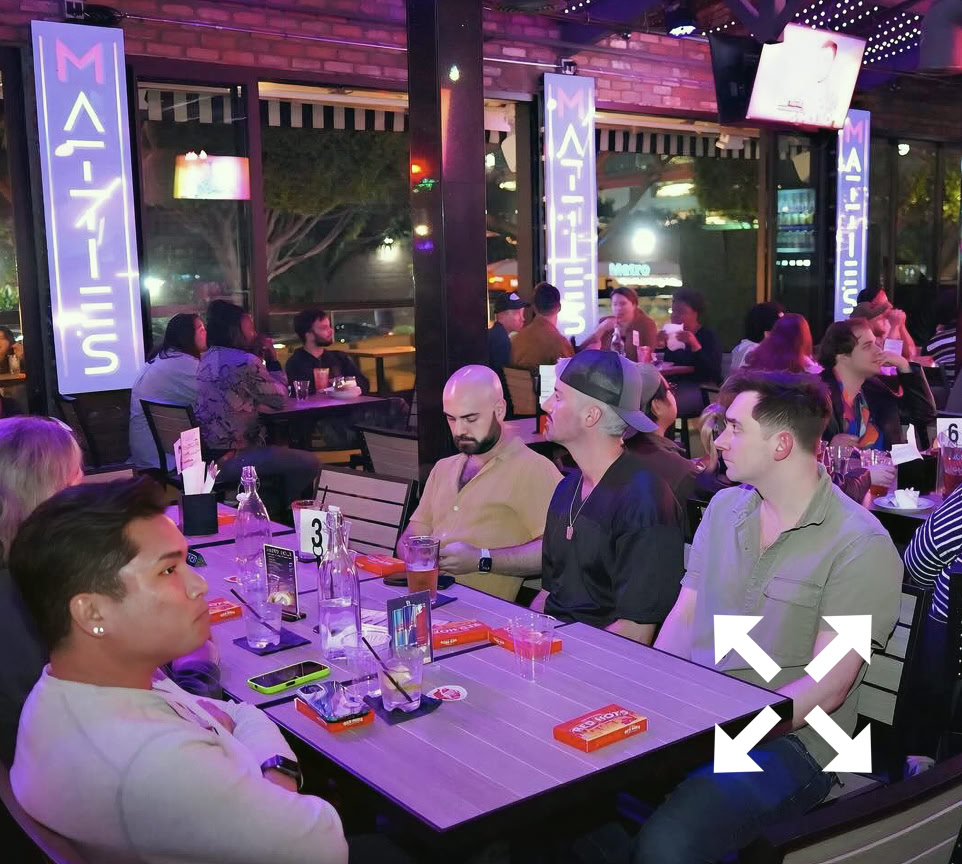 A woman enjoying red wine at a romantic candlelit dinner, perfect for celebrations.